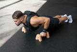 Athlet trainiert mit bmotion Gewichtsweste 10kg Push-ups auf Parallettes - Calisthenics Bodyweight Training