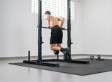 Athlet führt Dips an der Bmotion Power Rack Station aus, mit Gewichtsgürtel und 20kg Kettlebell an Kette für Zusatzgewicht