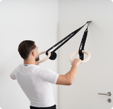 Athlet führt Ruderübung mit Bmotion Turnringen an der Tür aus – funktionelles Training mit Eigengewicht, Rückenansicht.